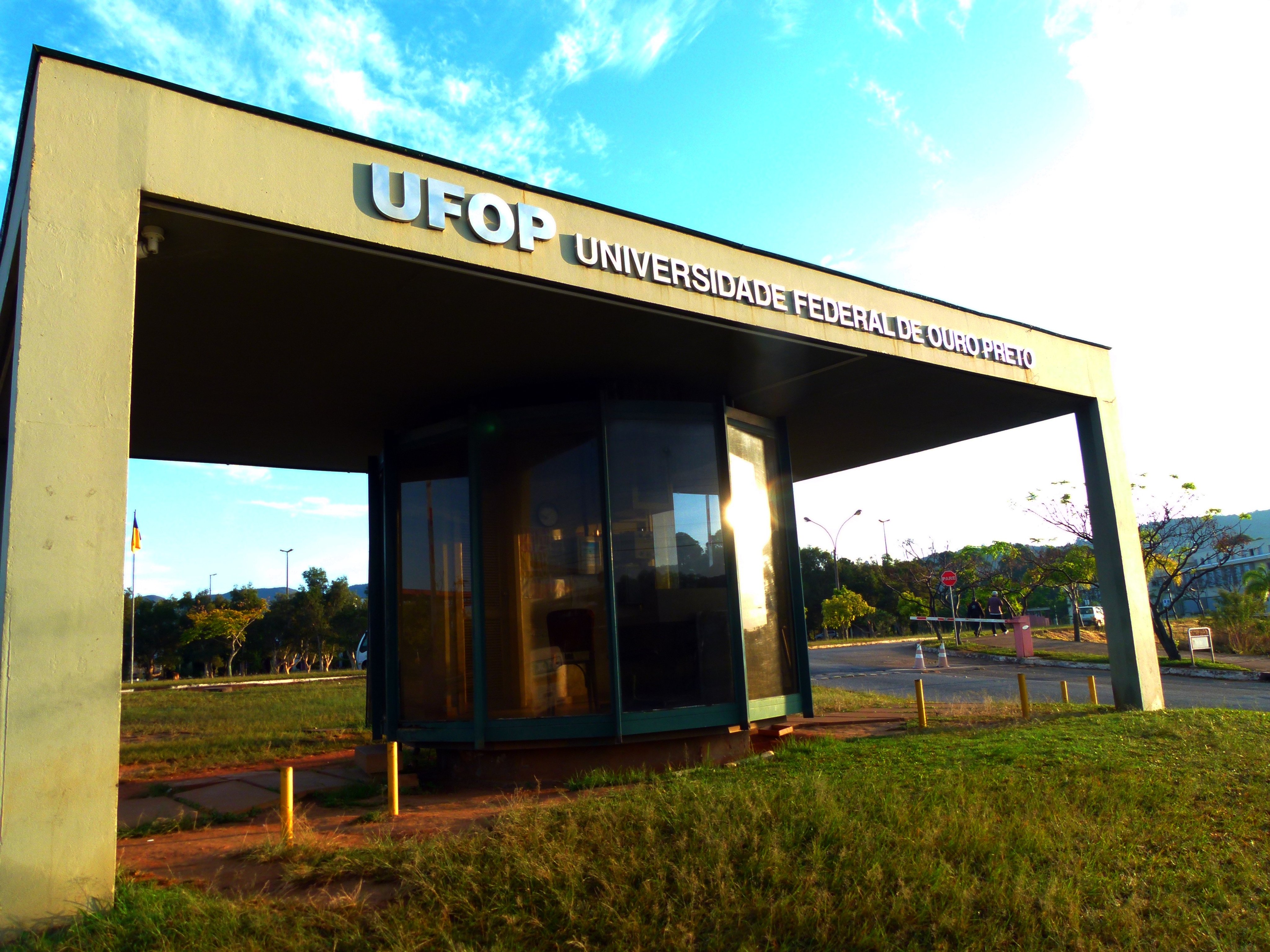 Fachada de prédio da UFOP em Mariana, Minas Gerais, com ambiente acadêmico ao fundo.