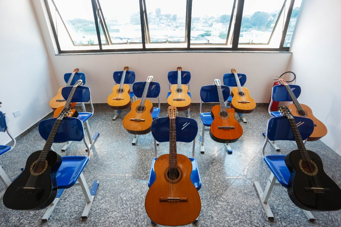 Cena de educação musical: sala com instrumentos de cordas dispostos nas cadeiras.