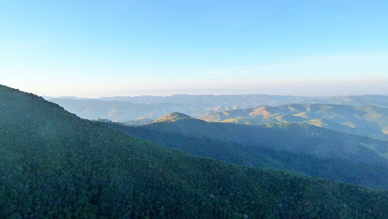 Paisagem de caatinga na Bahia, com morros rochosos e vegetação esparsa sob céu azul