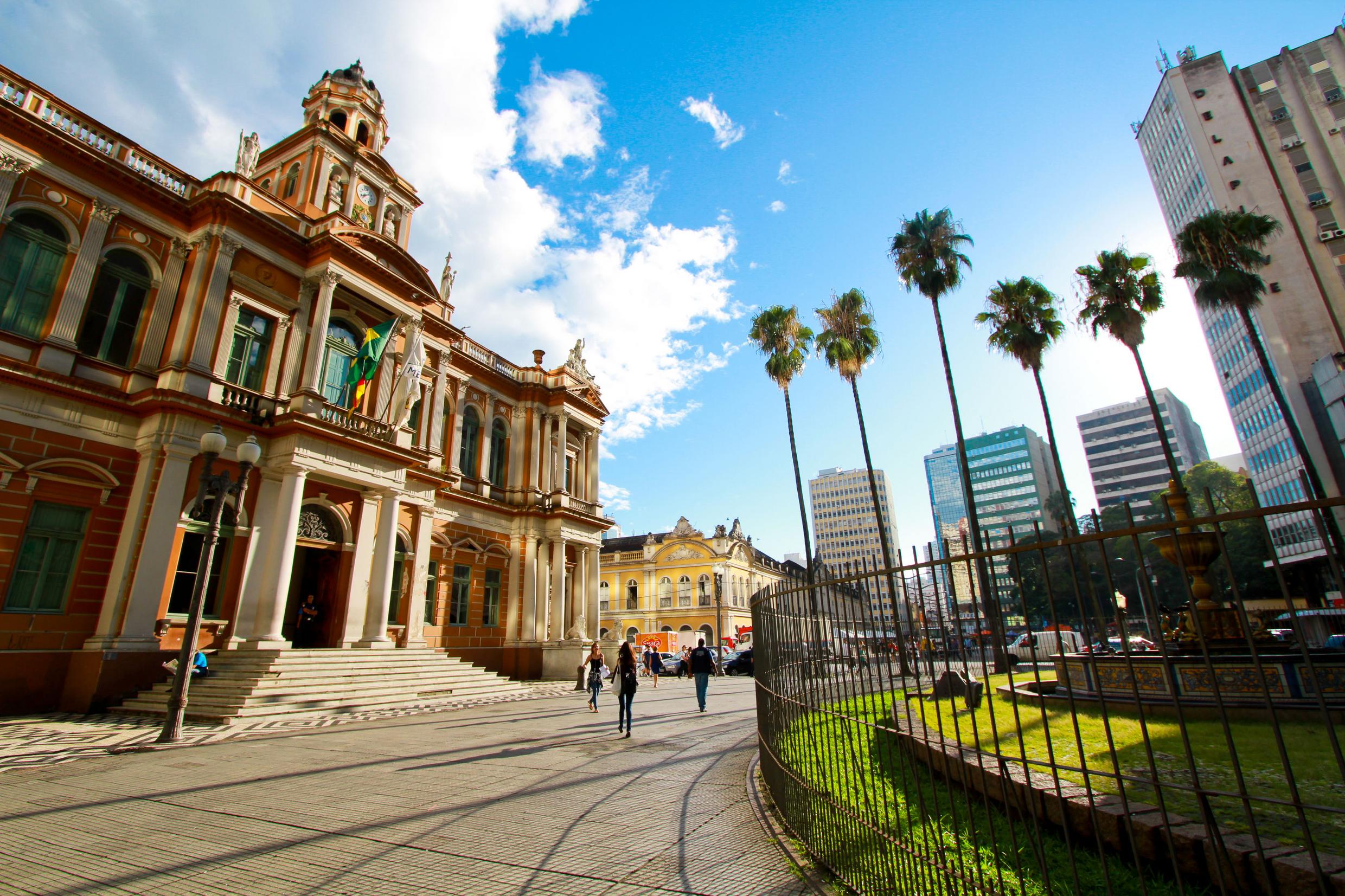 Fachada do Paço Municipal de Porto Alegre (Prefeitura), com movimento de pedestres em dia ensolarado