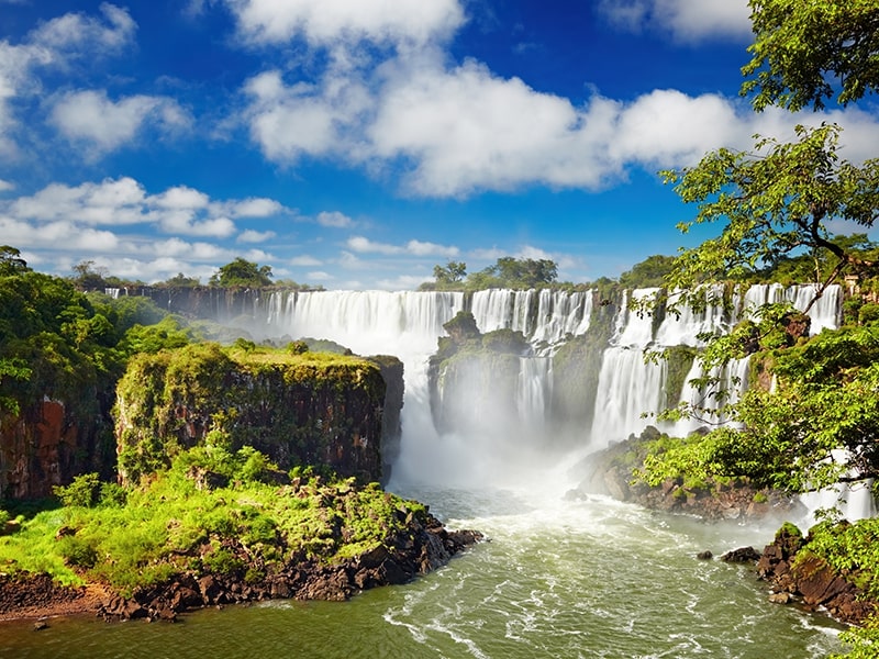 Cataratas do Iguaçu em dia claro, com quedas d’água e vegetação ao redor