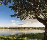 Paisagem da Lagoa Santa com espelho d’água, vegetação e morros ao fundo