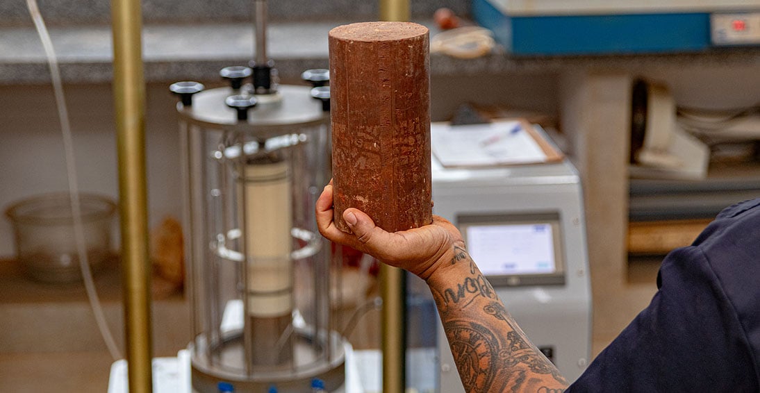 Ambiente de laboratório com amostras de concreto e equipamentos de ensaio, ilustrando pesquisa em materiais de construção