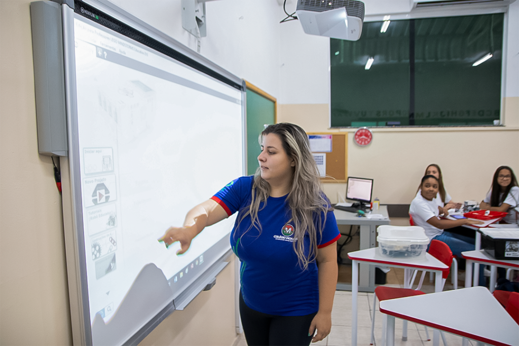Sala de aula do ensino fundamental com carteiras alinhadas e lousa em ambiente claro