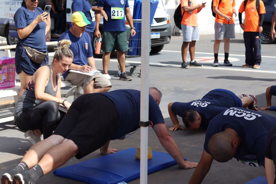 Candidatos realizando atividade física em espaço aberto, com cones de marcação, ilustrando etapa de TAF.