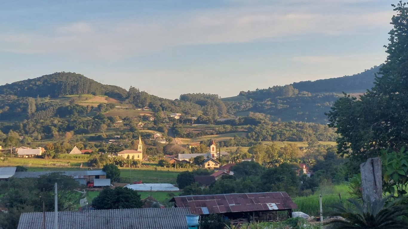 Vista aérea de cidade no Vale do Caí, com morros verdes e arquitetura típica