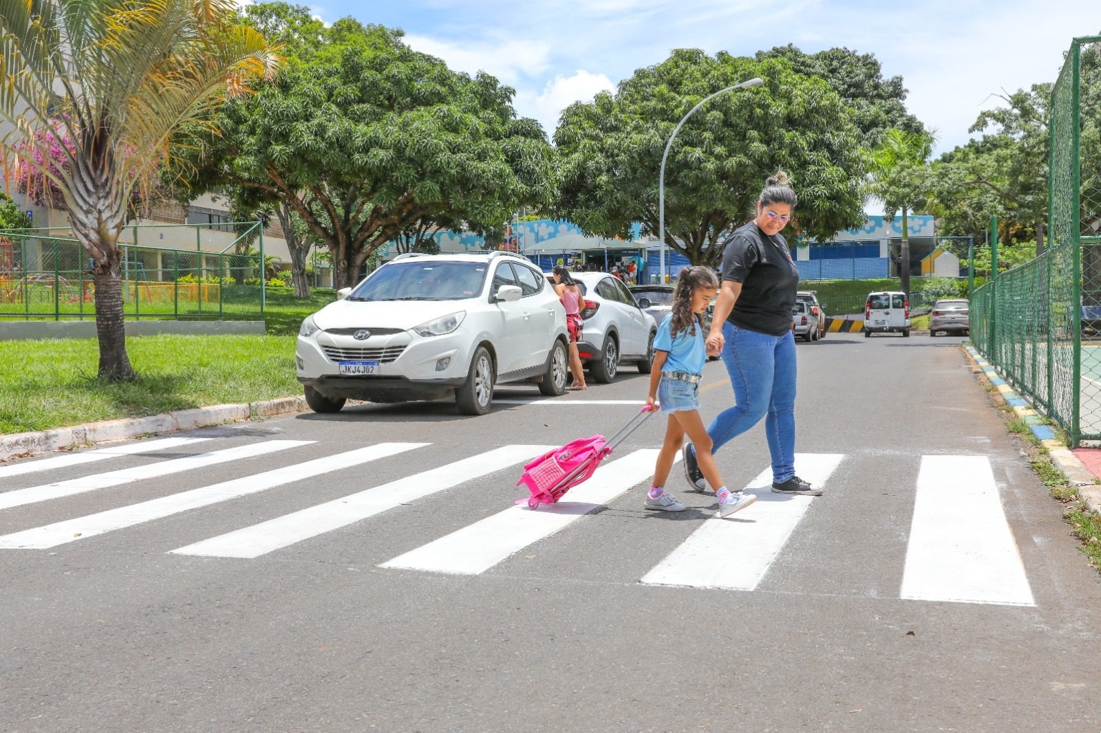 Faixa de pedestres e sinalização viária, com movimento leve ao entardecer