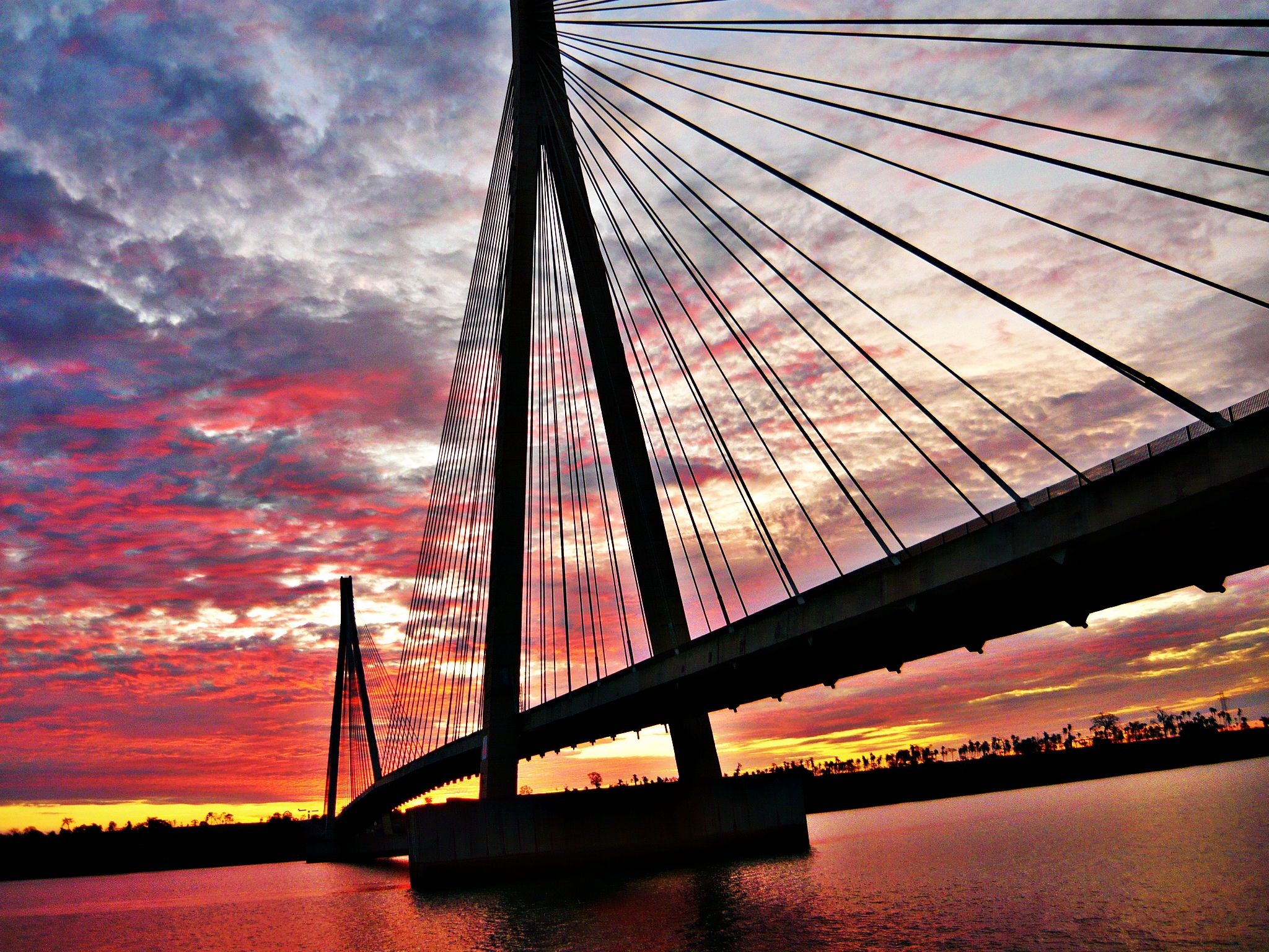 Vista aérea de Paranaíba MS ao pôr do sol, com ponte e área urbana ao fundo
