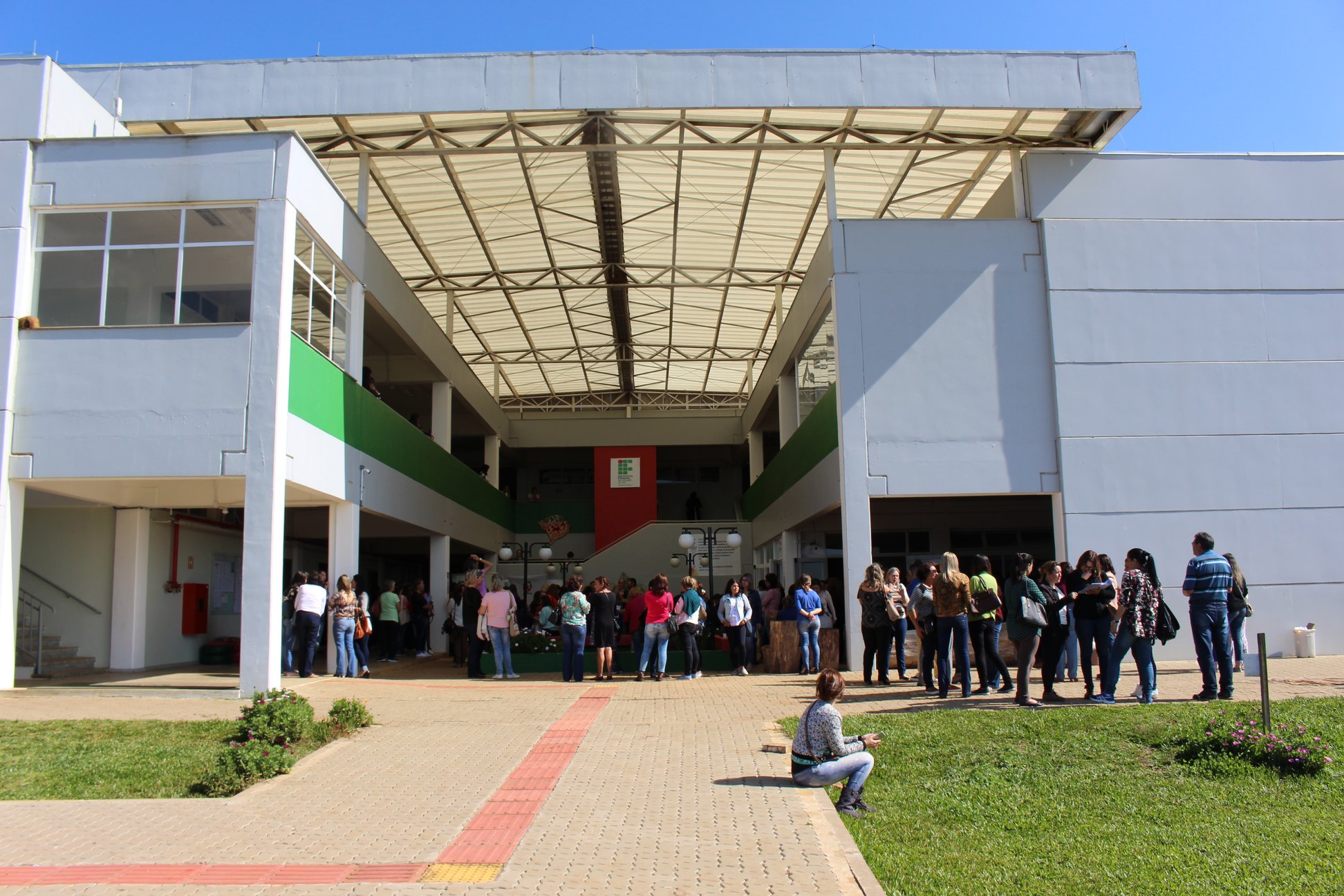 Fachada do campus do Instituto Federal do Rio Grande do Sul, com circulação de estudantes em área externa, em dia nublado