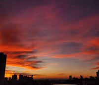 Vista aérea do skyline de Campinas SP ao entardecer, com prédios modernos e áreas verdes.