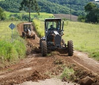 Manutenção viária no interior de Santa Catarina, com motoniveladora em operação ao entardecer (Foto: Prefeitura de Novo Horizonte).