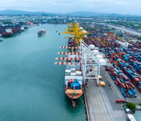 Vista aérea do Porto de Santos, com terminais de contêineres e navios; linha costeira ao fundo