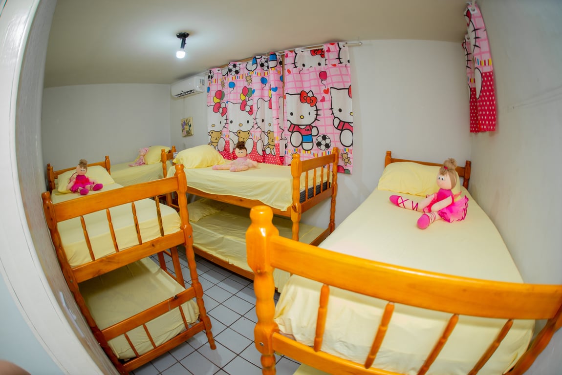 Ambiente acolhedor de casa-lar, com beliches e decoração infantil