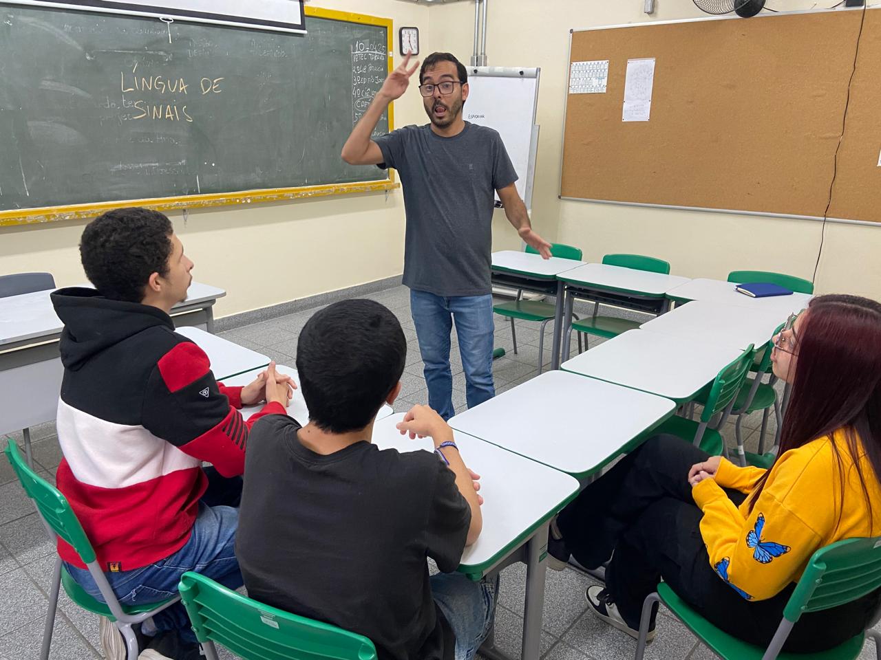 Aula de Libras: professor sinaliza para estudantes em contexto inclusivo