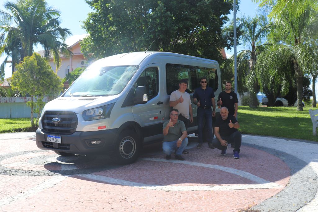 Pessoa ao lado de van de transporte de pacientes; ilustração de serviço de saúde municipal
