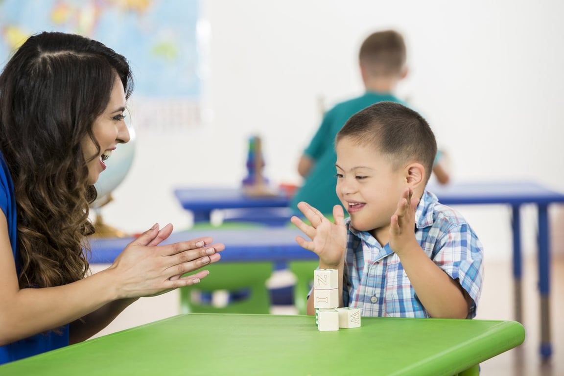 Sala de aula do ensino fundamental no Brasil, com professora e aluno em atividade pedagógica