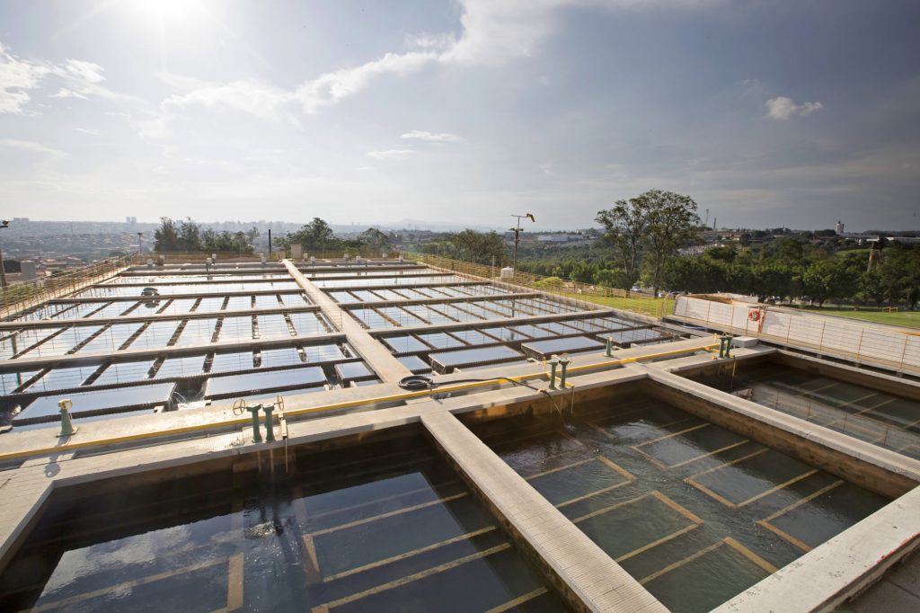 Estruturas de uma estação de tratamento de água e esgoto, em cenário diurno