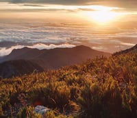 Amanhecer nas montanhas do Parque Nacional do Caparaó, com céu colorido e nuvens sobre os picos