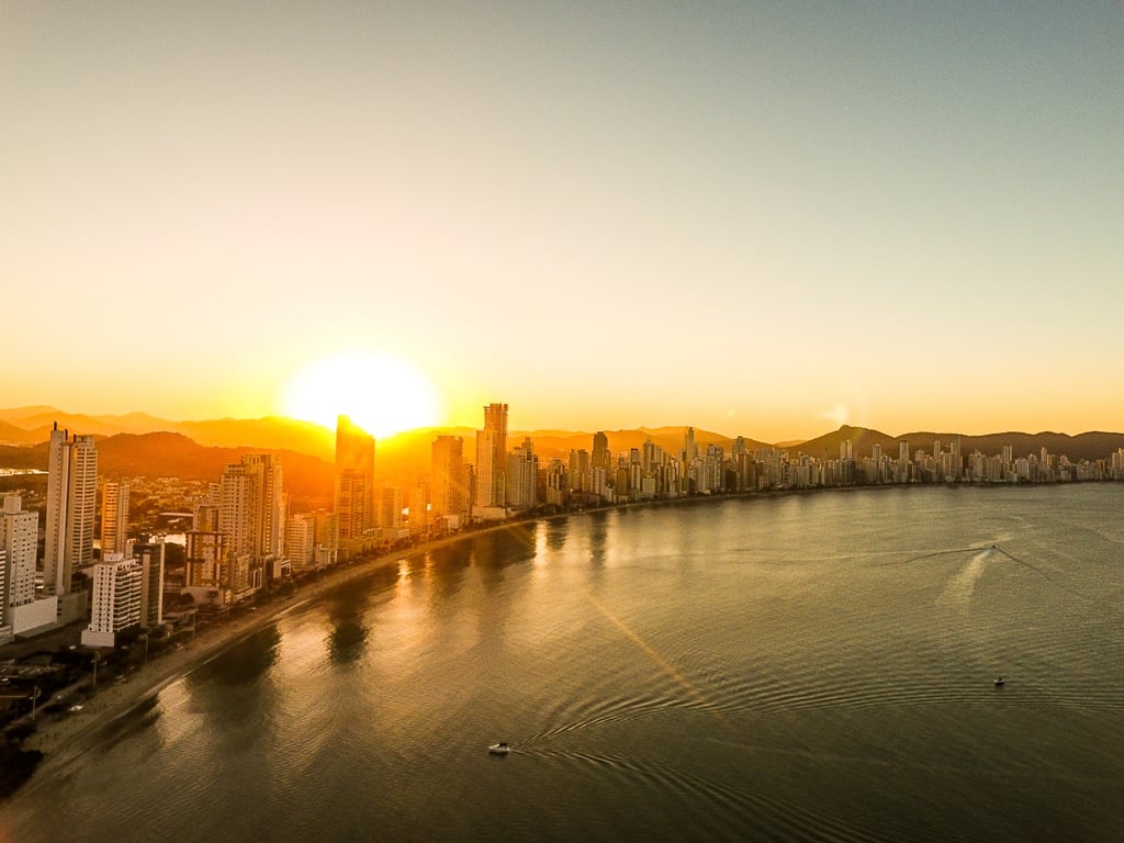 Skyline de Balneário Camboriú ao entardecer, com a orla e os prédios iluminados