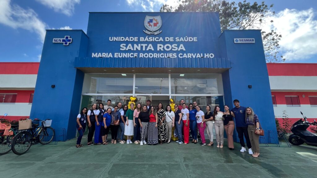 Profissionais de saúde em frente a Unidade Básica de Saúde