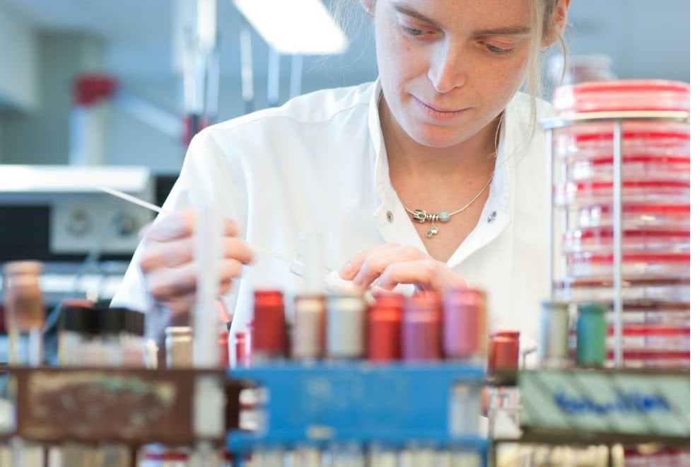 Ambiente acadêmico de microbiologia, com manipulação de placas de Petri e microscopia