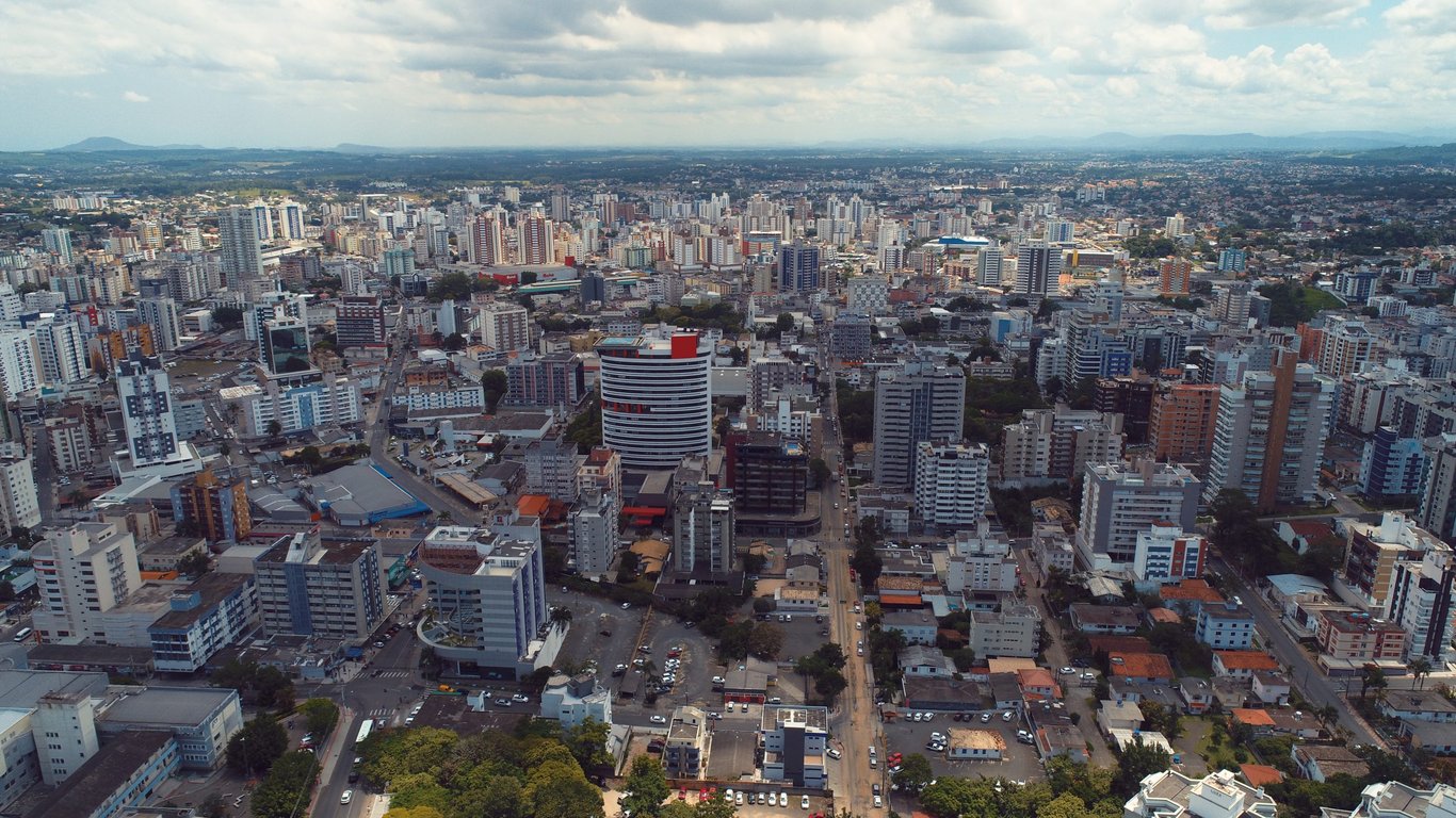 Vista aérea de Criciúma, Santa Catarina, mostrando o centro da cidade em uma tarde ensolarada.