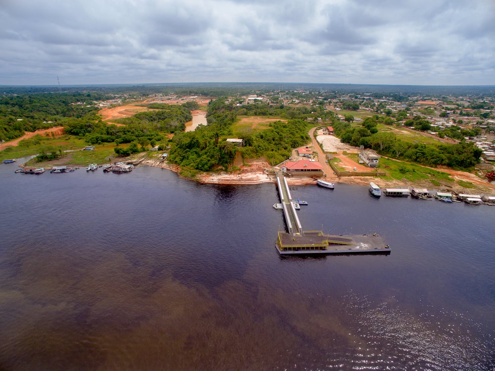 Rio amazônico com margem urbana e barcos, representando Manacapuru AM