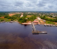 Rio amazônico com margem urbana e barcos, representando Manacapuru AM