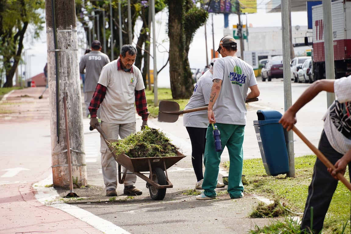 Trabalhadores de serviços gerais realizando limpeza em praça ao amanhecer