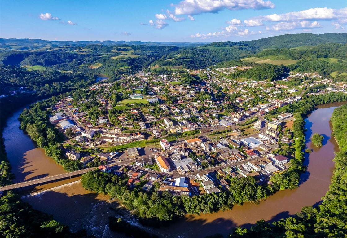 Vista aérea de Tangará SC, com áreas urbanas e vinhedos ao fundo.