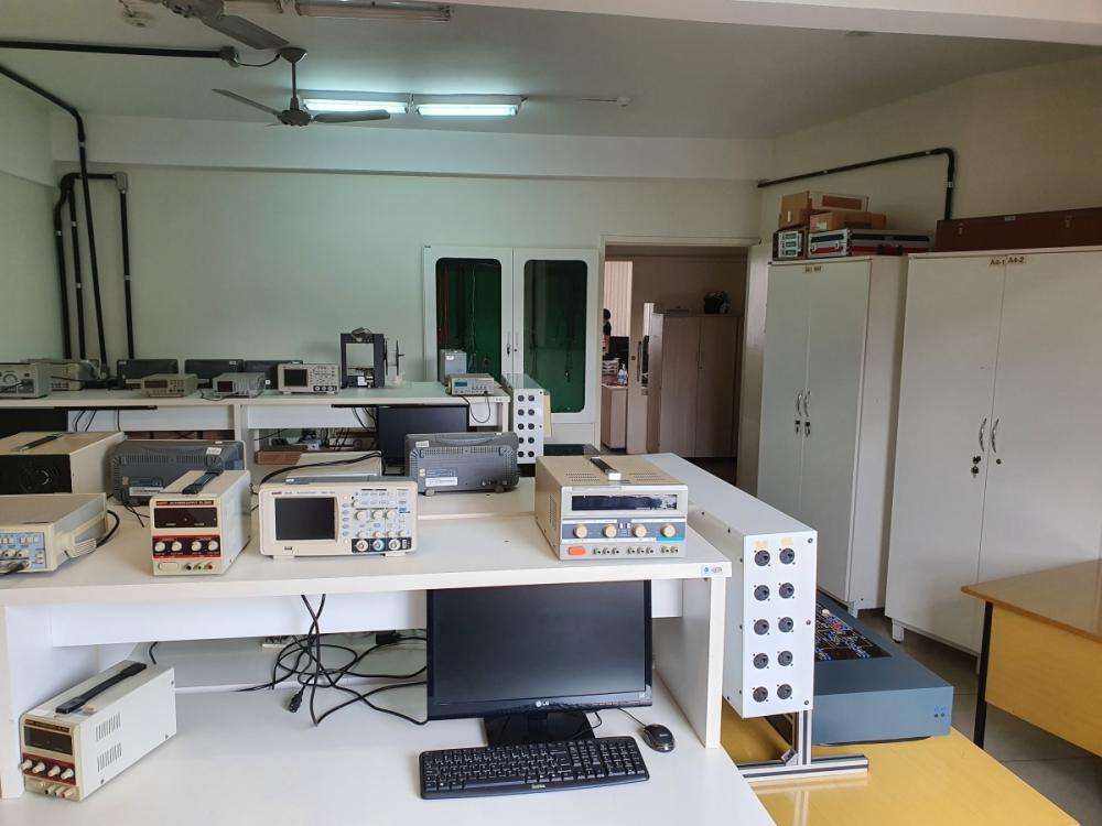 Laboratório de engenharia com osciloscópios e bancadas de teste