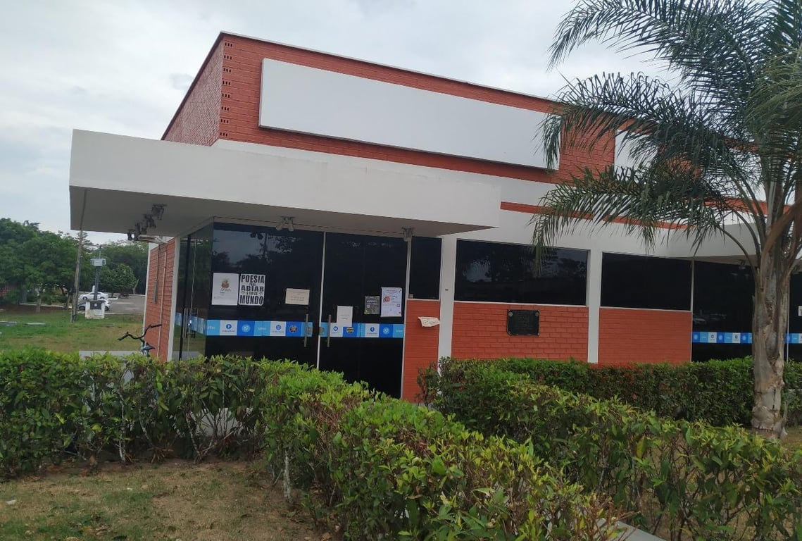 Fachada da Universidade Federal do Acre, em dia claro, com vegetação ao redor