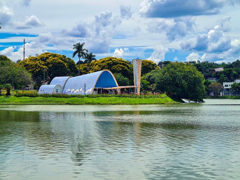 Vista panorâmica da Lagoa da Pampulha em Belo Horizonte, com arquitetura moderna à beira d'água ao entardecer