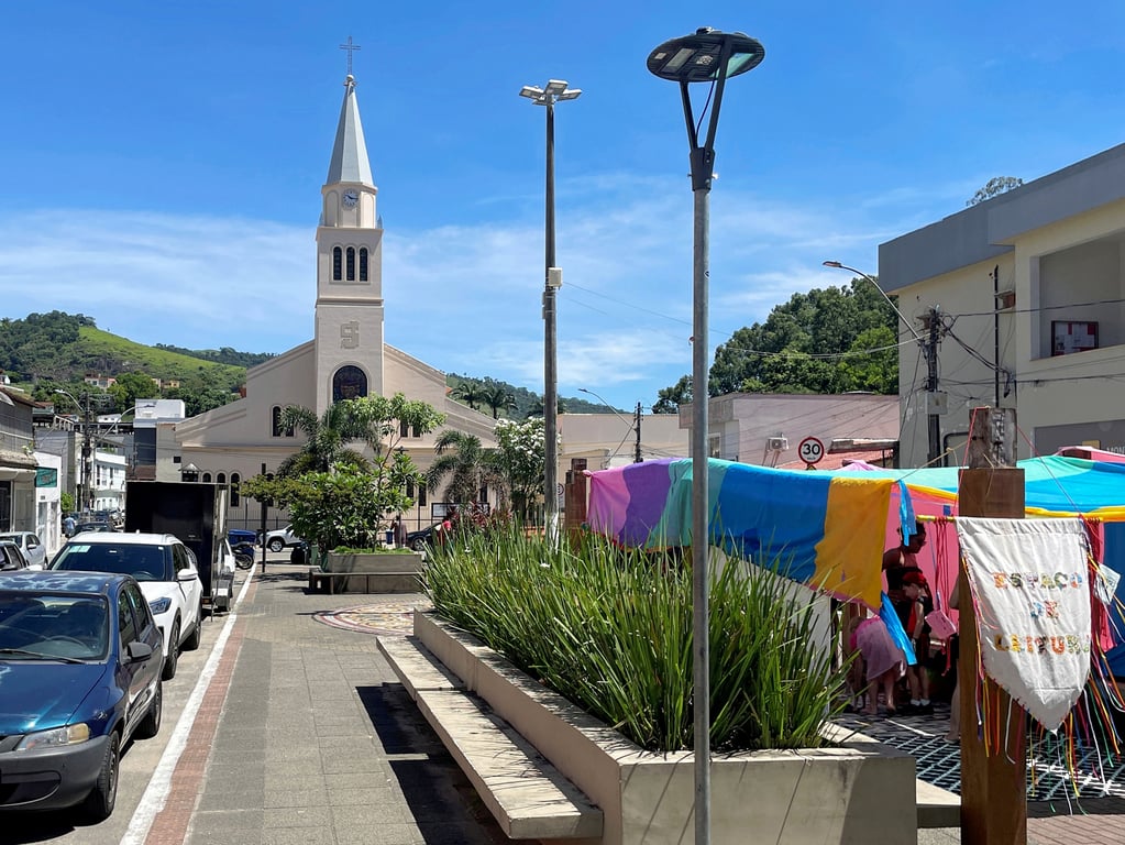 Centro de João Neiva ES com igreja ao fundo e movimento na praça