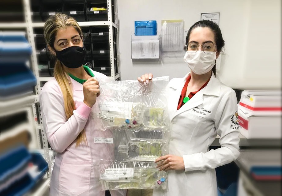 Profissionais farmacêuticas organizando medicamentos em farmácia clínica