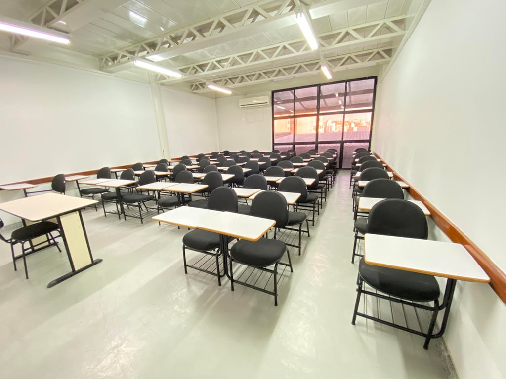 Sala de aula do ensino fundamental, com carteiras e lousa, luz natural e ambiente neutro