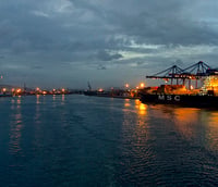 Vista do Porto de Itajaí ao entardecer, com guindastes e contêineres