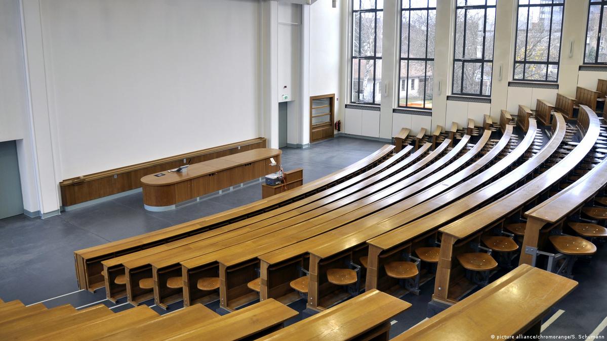 Sala de aula universitária moderna com iluminação natural e assentos em arquibancada