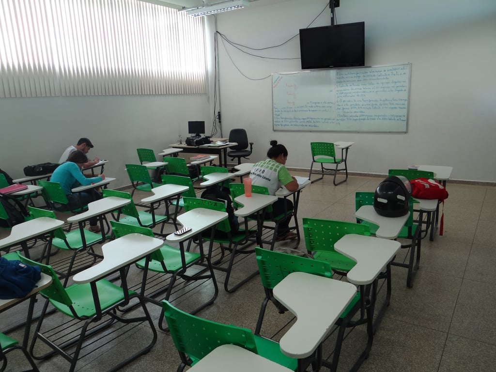 Sala de aula moderna, com estudantes e professor em ambiente acadêmico