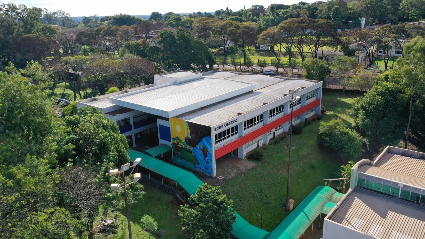 Fachada do IFPR com área verde e circulação de estudantes