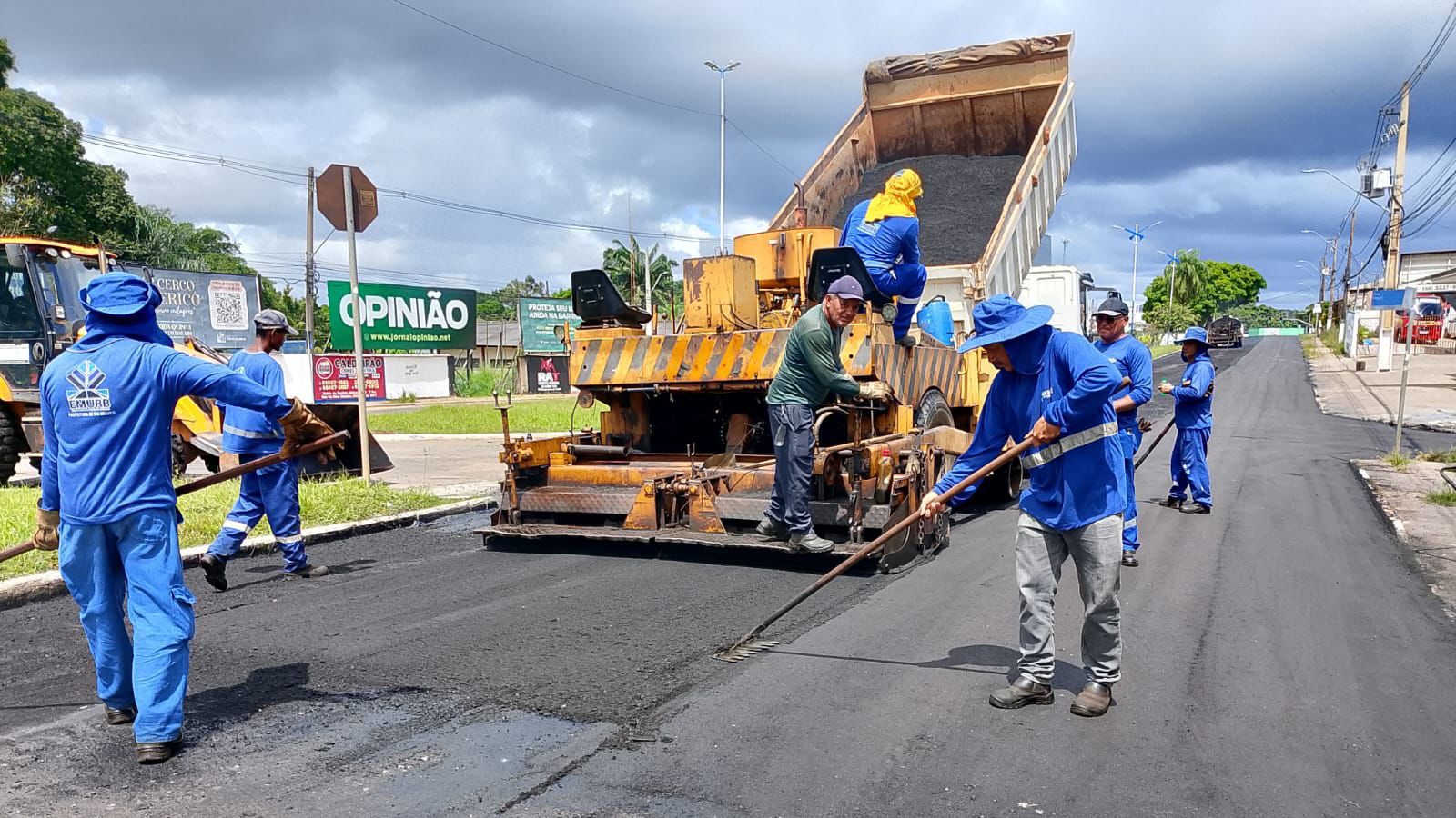 Servidores de manutenção urbana em ação, com maquinário a céu aberto