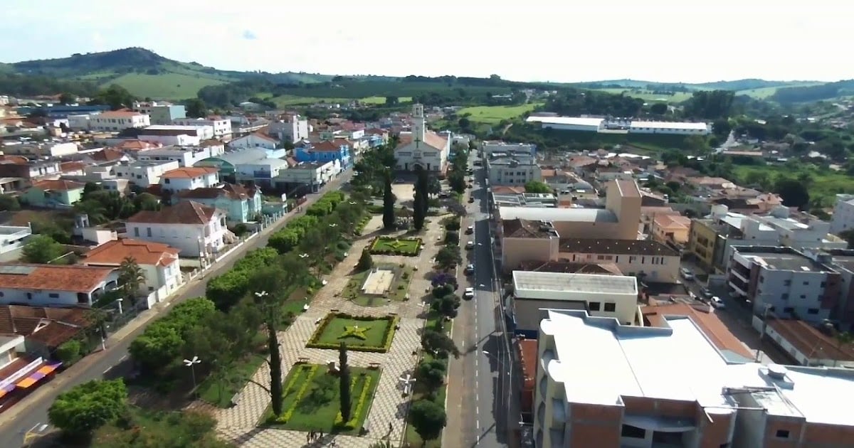 Vista aérea no Sul de Minas, com praça central e igreja matriz ao pôr do sol