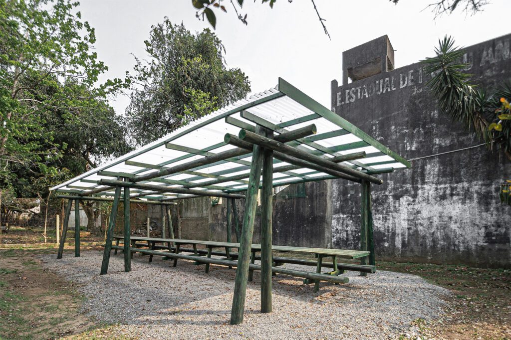 Ambiente externo de campus universitário, com árvores e área de convivência