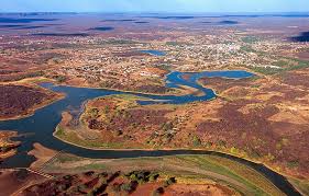 Foto aérea da cidade de São Raimundo Nonato, Piauí, mostrando a área urbana em meio à caatinga e com rios ao redor.