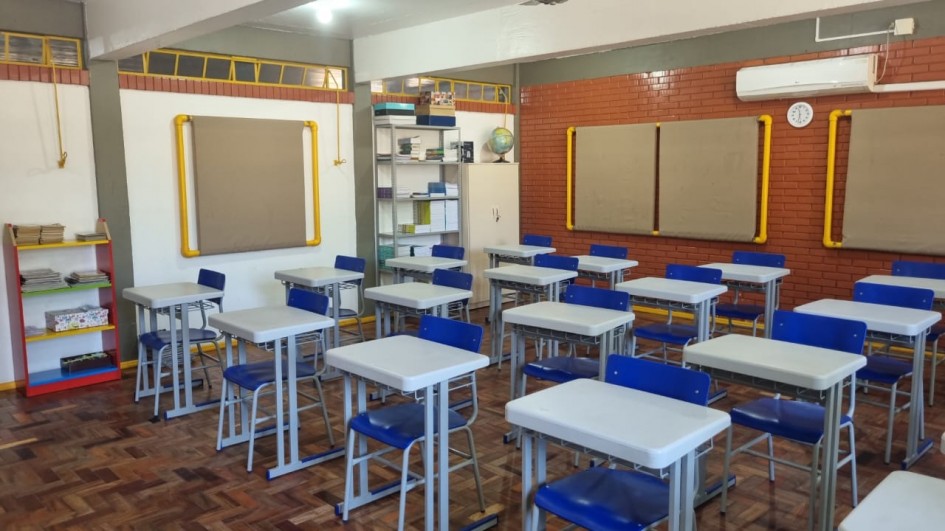 Ambiente escolar público, com carteiras e material didático, representando a rede municipal de ensino