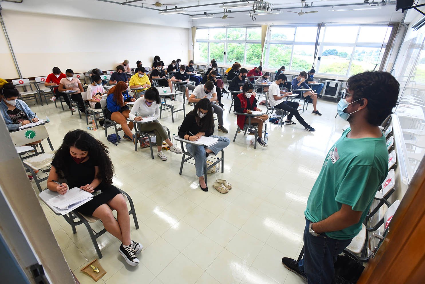 Candidatos em sala realizando prova escrita
