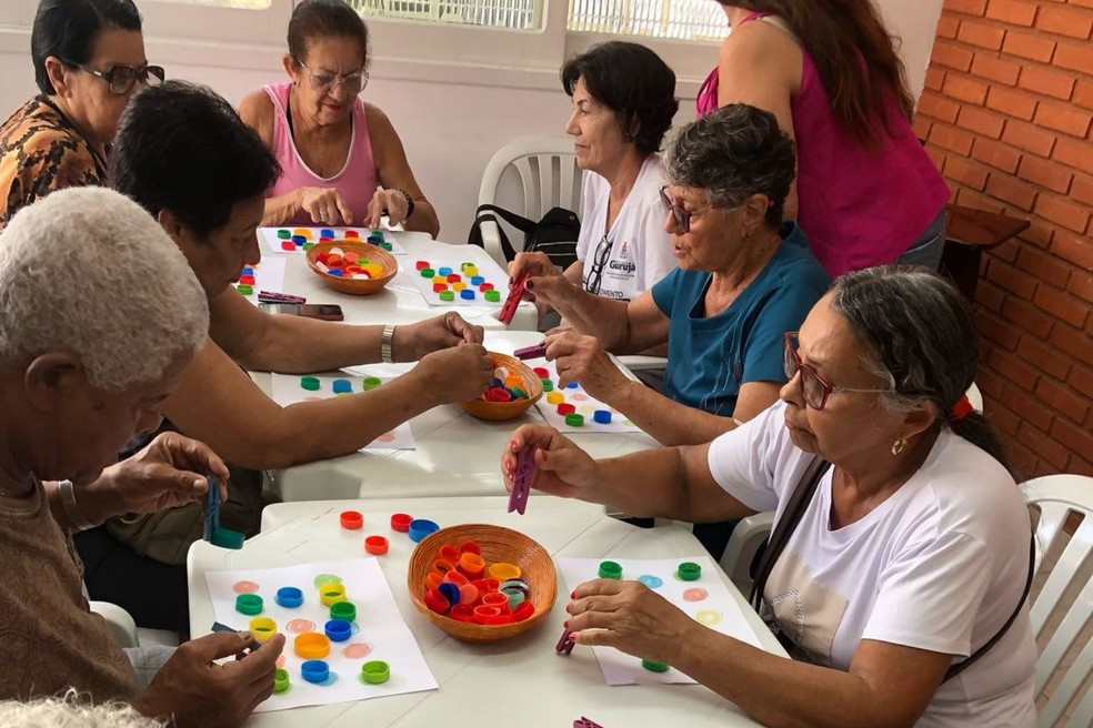 Ambiente comunitário com idosos e adultos em atividades de integração, representando assistência social
