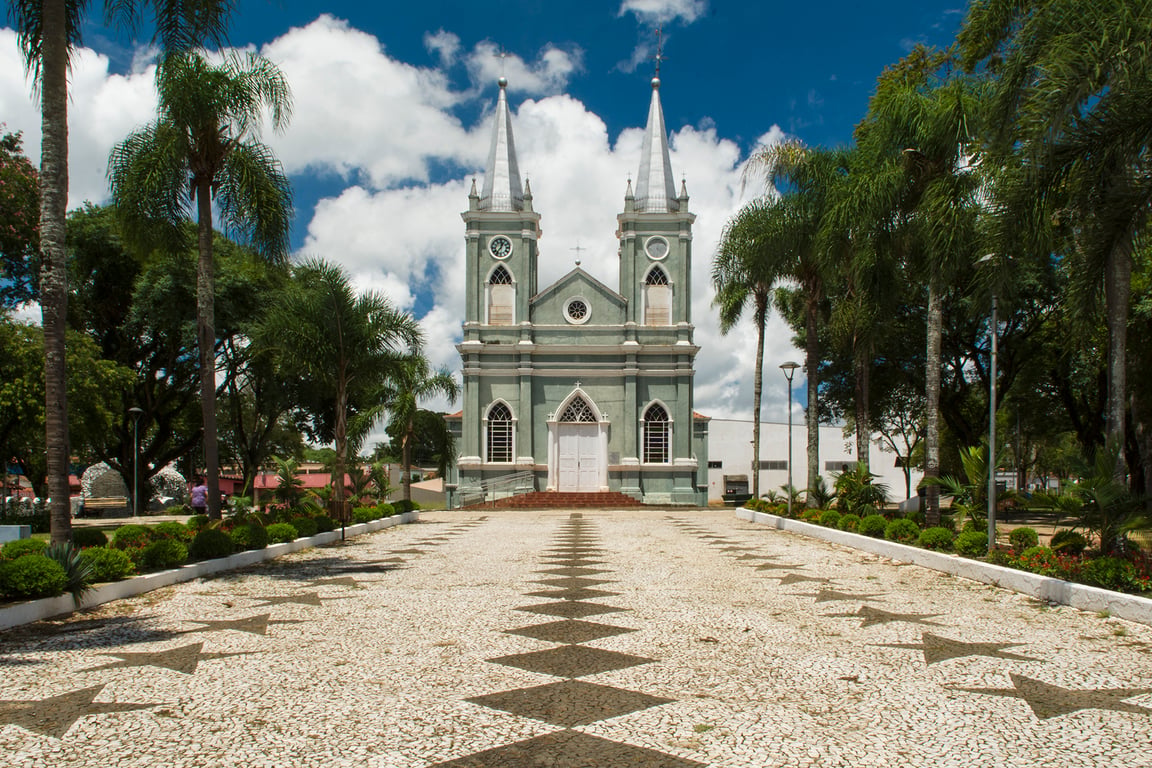 Centro urbano de pequena cidade do interior do Paraná, com igreja e ruas arborizadas, em composição horizontal