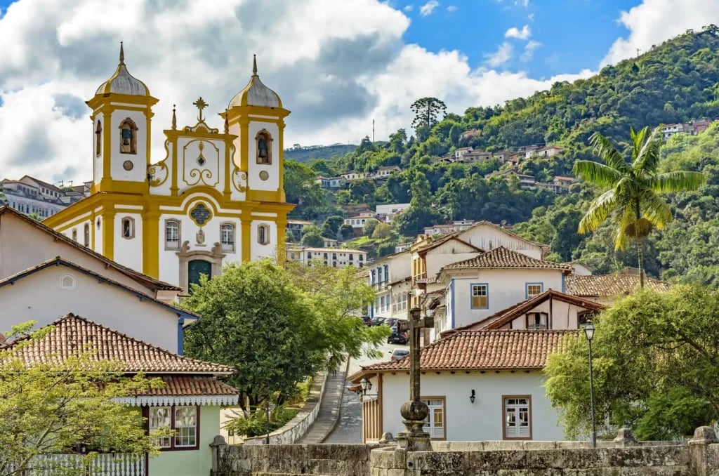Vista urbana de Oratórios MG, com igreja e casario, em perspectiva panorâmica