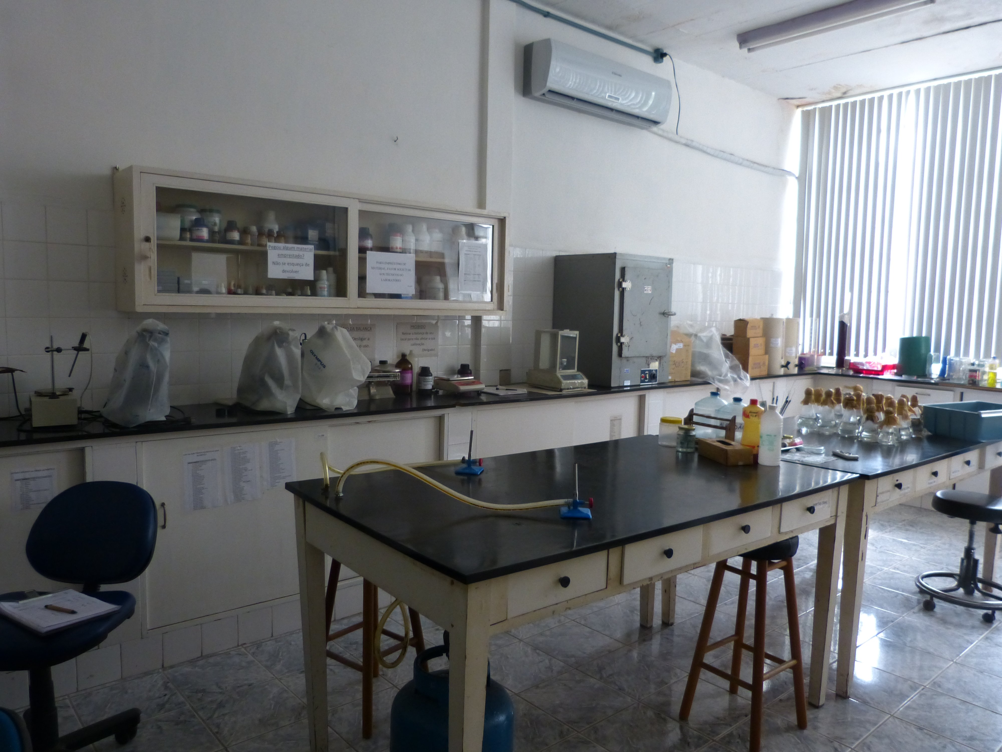 Laboratório acadêmico com bancadas e equipamentos, representando ambiente de ensino técnico-científico